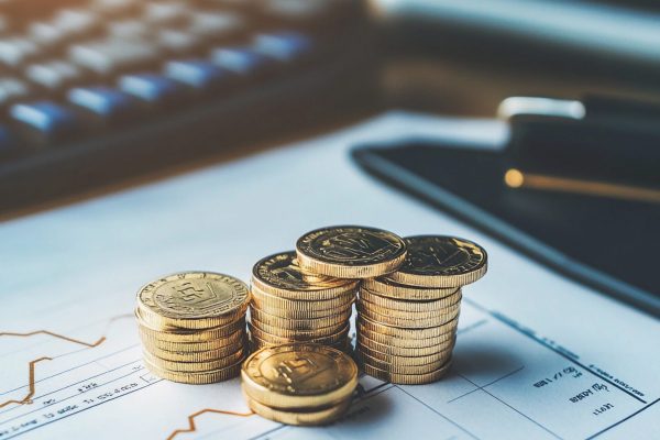 stacked-coins-financial-documents-with-calculator-nearby